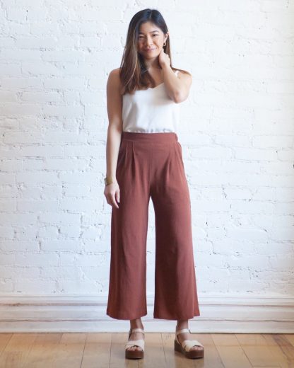 Woman wearing the Emerson Crop Pant sewing pattern from True Bias on The Fold Line. A trouser pattern made in linen, cotton, rayon challis, chambray or lightweight denim fabrics, featuring a pull-on style, cropped length, wide leg, elasticised back, flat front waistband, high rise, front pleats and side pockets.