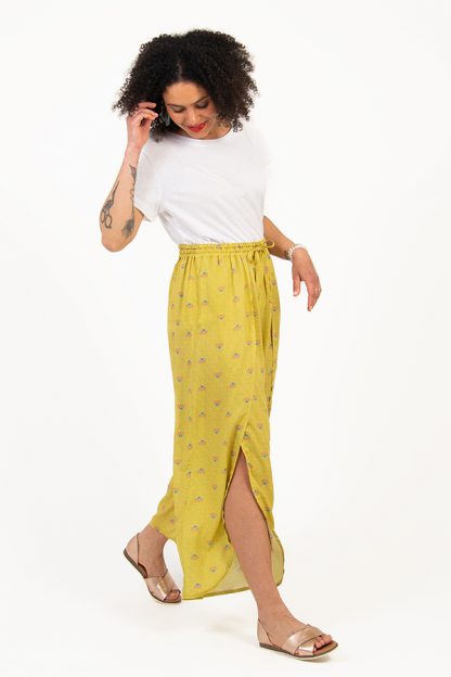 Woman wearing the Hélios Trousers sewing pattern from I AM Patterns on The Fold Line. A trouser pattern made in rayon, silk, lyocell, cupro, cotton crêpe or viscose crêpe fabrics, featuring an elasticated waistband with drawstring, full length front opening leg and rounded hem.