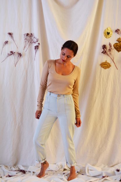 Woman wearing the Hussard Jeans sewing pattern from Maison Fauve on The Fold Line. A trouser pattern made in denim, wool suiting, cotton twill or jacquard fabrics, featuring a high waist, hip hugging, tapered leg, back patch pockets, front pockets, pleat detail, topstitching and fly zip closure.
