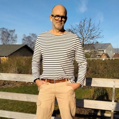 Man wearing the Men's Breton T-shirt sewing pattern from Wardrobe by Me on The Fold Line. A t-shirt pattern made in T-shirt jersey fabrics, featuring a straight silhouette, long set-in sleeves and boat neckline that is folded under and stitched.