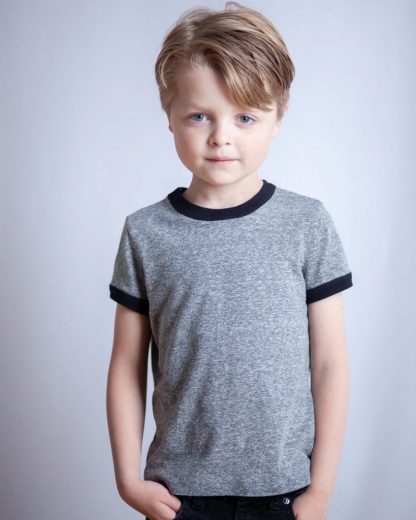 Child wearing the Mini Rio Ringer T-shirt sewing pattern from True Bias on The Fold Line. A t-shirt pattern made in light to medium weight knit fabrics, featuring contrasting ribbing around the crew neckline and short sleeves.