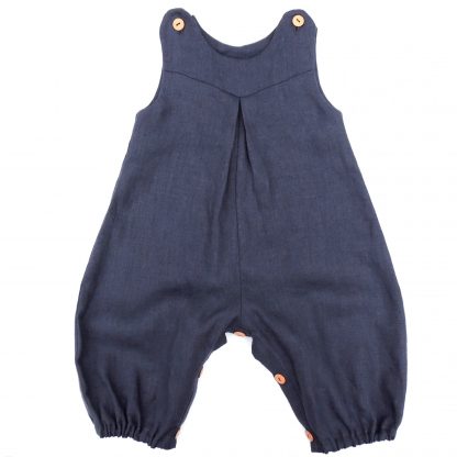 Image showing the Babies' Penny Romper sewing pattern from Dhurata Davies Patterns on The Fold Line. A romper pattern made in light to medium weight woven fabrics, featuring snap fasteners on the shoulders and leg inseam, front V shaped yoke, inverted front pleat detail, neckline facings and elasticated hems.