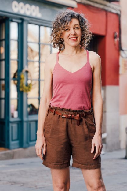 Woman wearing the Tribeca Knit Cami sewing pattern from Liesl + Co on The Fold Line. A cami pattern made in jersey fabrics, featuring a close fit with built-in bra, V-neck and 1/2″ straps that cross at the back.