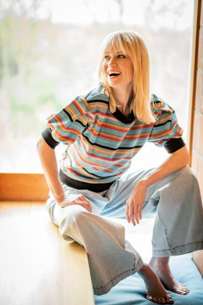 Woman wearing the Arielle Top sewing pattern from Fibre Mood on The Fold Line. A top pattern made in french terry, sweatshirt, thin or chunky-knit and ponte roma fabrics, featuring short gathered sleeves with pleat at the shoulders, round neck, relaxed fit and all edges finished in trim fabric.