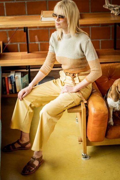 Woman wearing the Clover Trousers sewing pattern from Fibre Mood on The Fold Line. A cargo trouser pattern made in corduroy, velvet, denim, cotton twill or woven jacquard fabrics, featuring a high-waist, zip fly, straight legs, two angled front patch pockets, side pocket with pleat and flap, back pockets with hammer loop attached and topstitching.