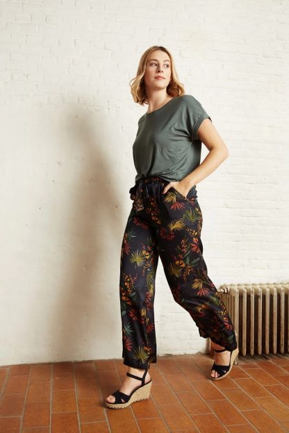 Woman wearing the Emily Trousers sewing pattern from Atelier Jupe on The Fold Line. A trouser pattern made in viscose or tencel fabrics, featuring a wide, loose-fit, small front pleats, side pockets and elasticated waistband.