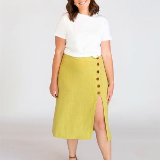 Woman wearing the Evelyn Skirt sewing pattern from Chalk and Notch on The Fold Line. A skirt pattern made in rayon’s, cotton lawn, cotton voile, linen, denim or flannel fabrics, featuring a high-waist, fitted through the waist, high slit, side-front buttons and midi length.