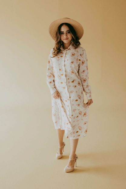 Woman wearing the Frances Shirt Dress sewing pattern from Pattern Sewciety on The Fold Line. A shirt dress pattern made in cotton, cotton blends, linen, linen blends, chambray or silk fabrics, featuring a two-piece collar, button front, cuffed sleeves, waist seam and straight skirt.