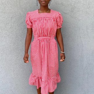 Woman wearing the 121 Guatemalan Gabacha sewing pattern from Folkwear on The Fold Line. A dress pattern made in cottons, rayon, linen or silk fabrics, featuring puffed sleeves with narrow straight cuff, centre back zipper, gathered at the front waist with a tie belt, shaped pockets, front and back gathered yoke and hem ruffle.