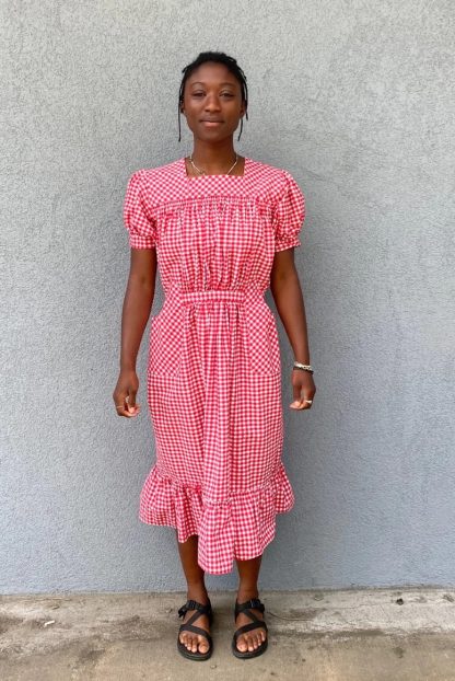 Woman wearing the 121 Guatemalan Gabacha sewing pattern from Folkwear on The Fold Line. A dress pattern made in cottons, rayon, linen or silk fabrics, featuring puffed sleeves with narrow straight cuff, centre back zipper, gathered at the front waist with a tie belt, shaped pockets, front and back gathered yoke and hem ruffle.