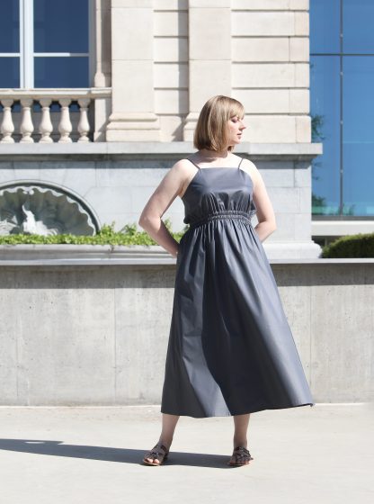 Woman wearing the Nina Dress sewing pattern from Lenaline Patterns on The Fold Line. A dress pattern made in cotton, cotton poplin, silk, linen or viscose fabrics, featuring an elasticated waist, in-seam pockets, adjustable spaghetti straps, midi length and relaxed fit.