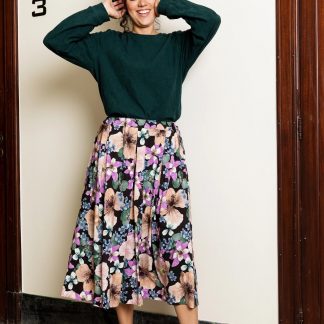 Woman wearing the Stina Skirt sewing pattern from Atelier Jupe on The Fold Line. A skirt pattern made in viscose, tencel, cotton, linen or polyester fabrics, featuring inverted pleats, side seam pockets mid-length finish and elasticated waistband.
