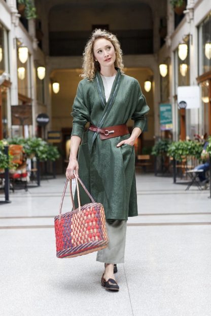 Woman wearing the 254 Swing Coat sewing pattern from Folkwear on The Fold Line. A swing coat pattern made in lightweight linen, gabardine, lightweight denim, soft cotton twill or silk taffeta fabrics, featuring a shawl collar, back yoke with deep pleat, sleeves narrow at the wrist and patch pockets.
