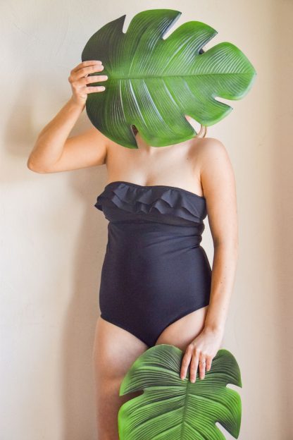 Woman wearing the Piña Swimsuit sewing pattern from Fitiyoo on The Fold Line. A swimsuit pattern made in two-way stretch fabrics, featuring no straps and bare shoulders, double ruffle at front bust, low rise leg and full back coverage.