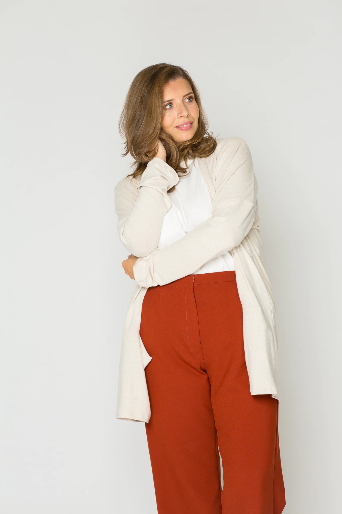 Woman wearing the Isa Cardigan sewing pattern from Bara Studio on The Fold Line. A cardigan pattern made in light to medium knit fabrics, featuring a relaxed fit, extra-long sleeves, front pockets and upper thigh length.