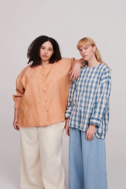 Women wearing the Leila Shirt sewing pattern from The Modern Sewing Co on The Fold Line. A shirt pattern made in poplin, muslins, linens, tencels or silk fabrics, featuring a loose fit, very dropped shoulders, full length sleeves, button front closure and back gathering details.