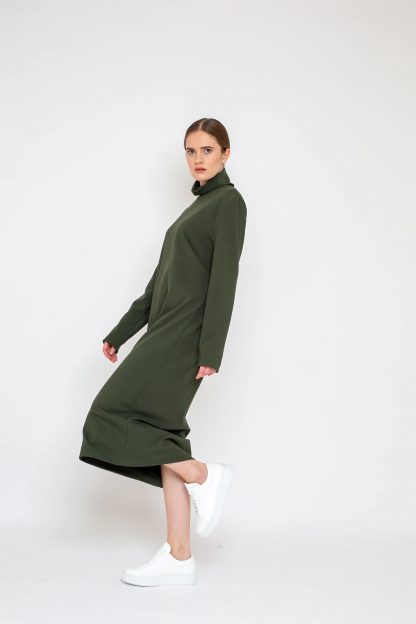 Woman wearing the Mila Dress sewing pattern from Bara Studio on The Fold Line. A dress pattern made in jersey, interlock or punta di roma fabrics, featuring a loose fit, turtleneck, longer than normal sleeves and midi length.