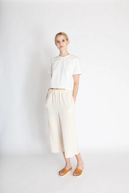 Woman wearing the Nova Pants sewing pattern from Bara Studio on The Fold Line. A culottes pattern made in cotton, linen or tencel fabrics, featuring wide legs, relaxed fit, elasticated waist, back patch pocket, in-seam pockets, faux fly front and cropped length.