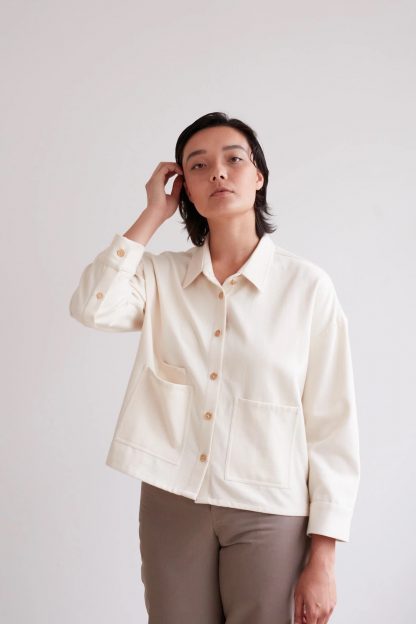 Woman wearing the Over Shirt sewing pattern from The Modern Sewing Co on The Fold Line. A shirt pattern made in denims, twills, cottons, linens or wool felt fabrics, featuring dropped shoulders, square cut, collar, front patch pockets, full length sleeves with button cuffs, back yoke and slight cropped length.