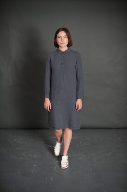 Woman wearing The Rugby Dress sewing pattern from Merchant & Mills on The Fold Line. A dress pattern made in light linens, fine wool, lightweight denim or silk fabrics featuring a semi-fit, rugby shirt style collar, cuffs and placket, full length sleeves and knee length hem.