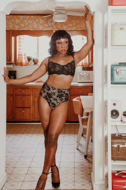 Model wearing the Adrian Transgender Bra and Panty sewing pattern from Madalynne on The Fold Line. A transgender bra and panty pattern made in 8 – 20% spandex fabrics, featuring a bra with a full band, underwire, scalloped lace edges on the upper cups, hook and eye closure at the centre back and adjustable shoulder straps. Panties are basic, high-waist, with extended gusset.
