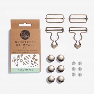 Photo showing the Dungarees Hardware Kit from Kylie & The Machine on The Fold Line. The kit includes: 2 x buckles (38 mm), 2 x sliders (38 mm), 6 x buttons and nails (17 mm buttons), 1 x instruction sheet and choose from, aged brass, aged copper, distressed silver or matte black finishes.