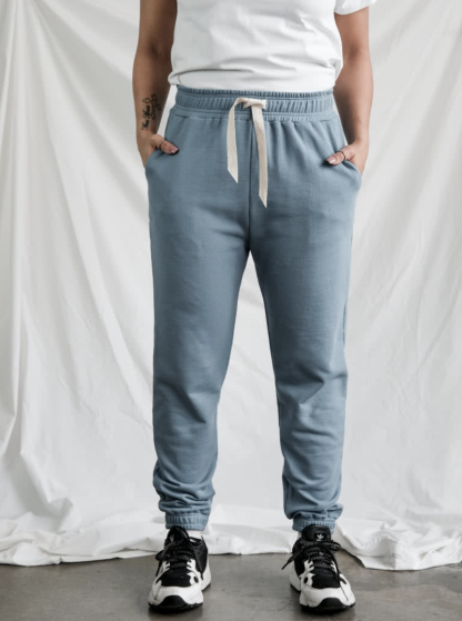 Woman wearing the Ernie Knit Pant sewing pattern from Style Arc on The Fold Line. A joggers pattern made in unbrushed fleece, fleece or rugby fabrics, featuring an elastic waistband with waist tie, elastic leg cuffs and angled front pockets.