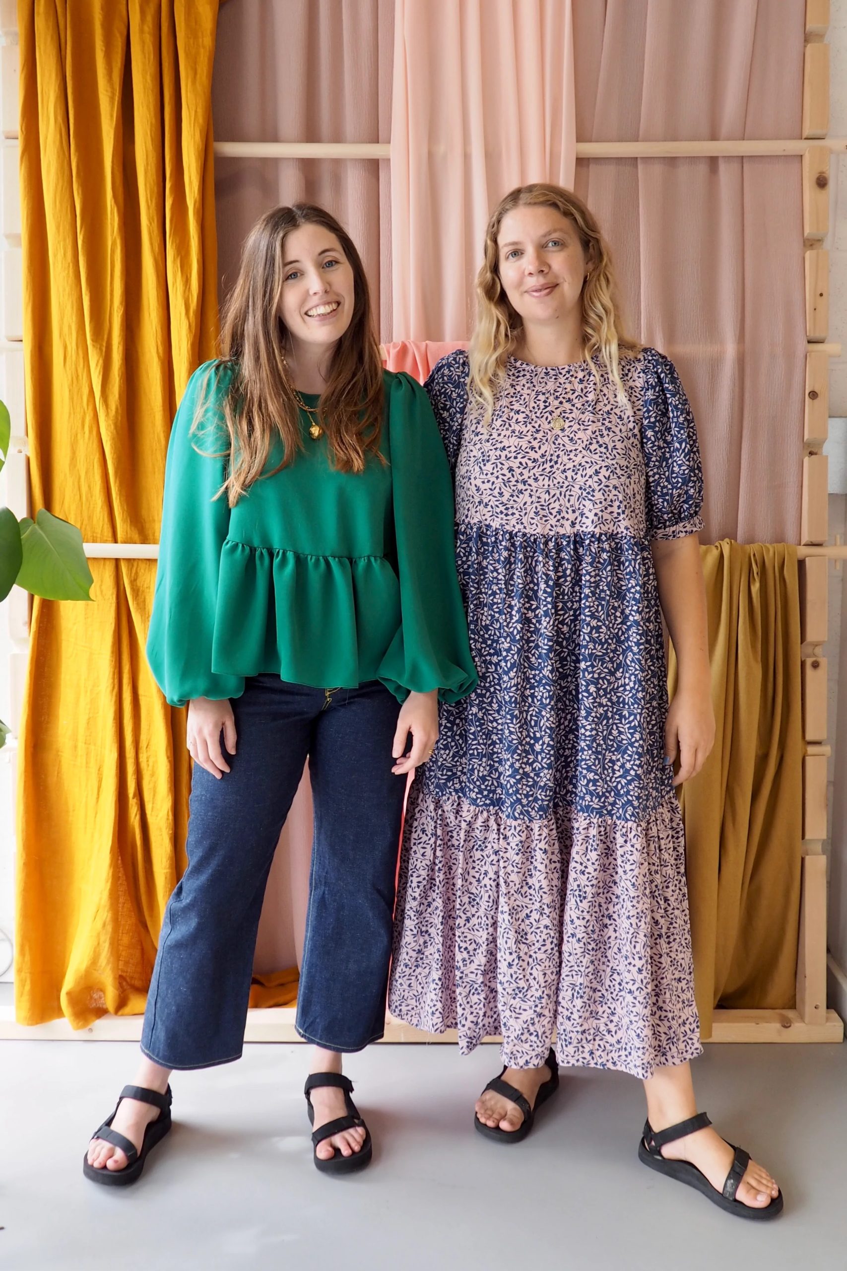 Women wearing the Everyday Dress and Top sewing pattern from The New Craft House on The Fold Line. A dress and top pattern made in linen, cotton or double gauze fabrics, featuring long or short puff sleeves, round neck, peplum for the top, tiered midi skirt for the dress, fitted on the shoulders then loose through the waist and button and loop back neck closure.