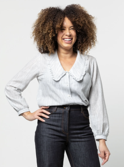 Woman wearing the Kennie Woven Shirt sewing pattern from Style Arc on The Fold Line. A shirt pattern made in cotton, voile or silk fabrics, featuring a button-front, large statement collar edged with frill, V-neck, bust darts and long sleeves with gathered cuff.