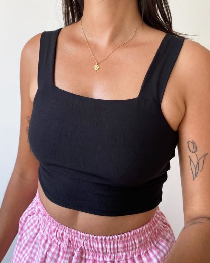 Woman wearing the Mia Crop Top sewing pattern from Tammy Handmade on The Fold Line. A crop top pattern made in 2-way stretch knit fabric such as jersey, ribbed knit or stretch velvet fabrics, featuring wide straps, cropped length, slip-on design, square neckline and no fastenings.