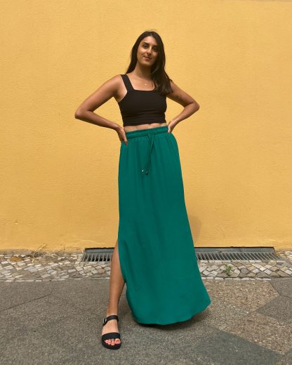 Woman wearing the Rani Skirt sewing pattern from Tammy Handmade on The Fold Line. A skirt pattern made in cotton, linen, viscose, rayon, satin or crepe fabrics, featuring a maxi length, side slits, slip-on style and elasticated drawstring waist.