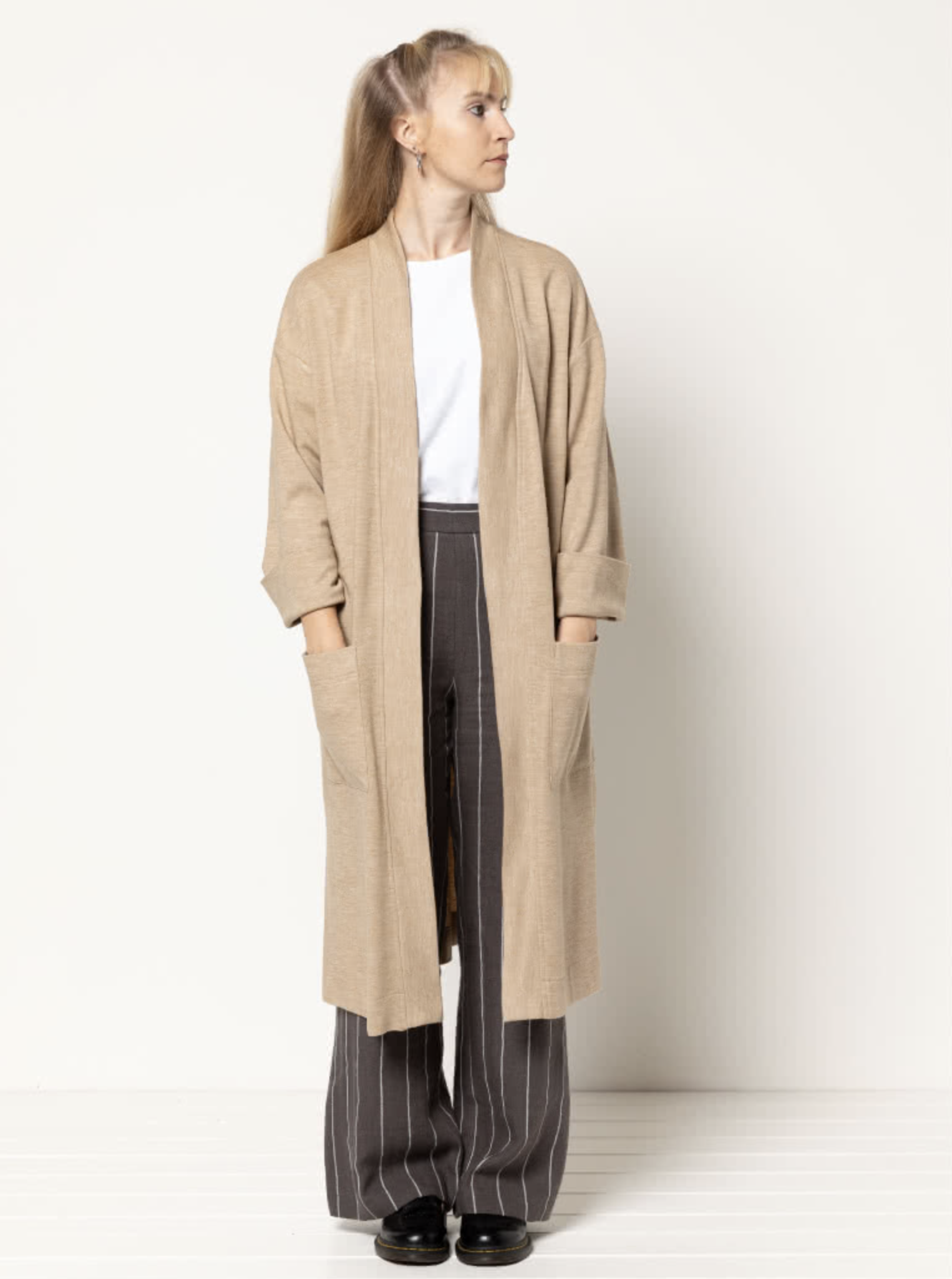 Women wearing the Sigrid Knit Coat sewing pattern from Style Arc on The Fold Line. A knit coat pattern made in sweater knit fabrics, featuring a longline silhouette, patch pockets, full length sleeves with folded over cuffs and hem with side splits.