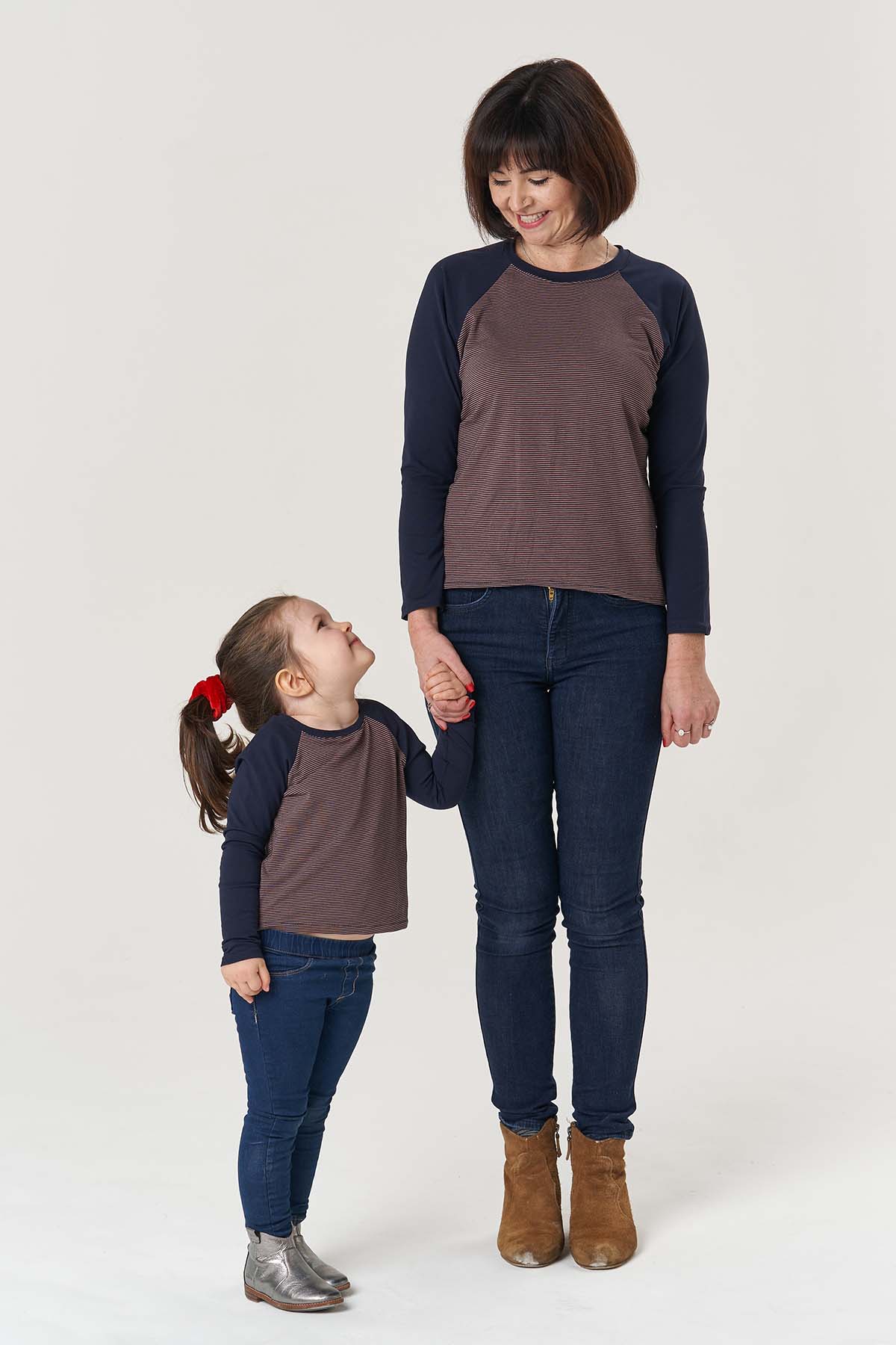 Child wearing the Baby/Child Mini Hebden T-shirt sewing pattern from Poppy & Jazz on The Fold Line. A T-shirt pattern made in cotton, viscose, tencel or bamboo jersey fabrics, featuring raglan full length sleeves, neckband and contrasting fabrics.