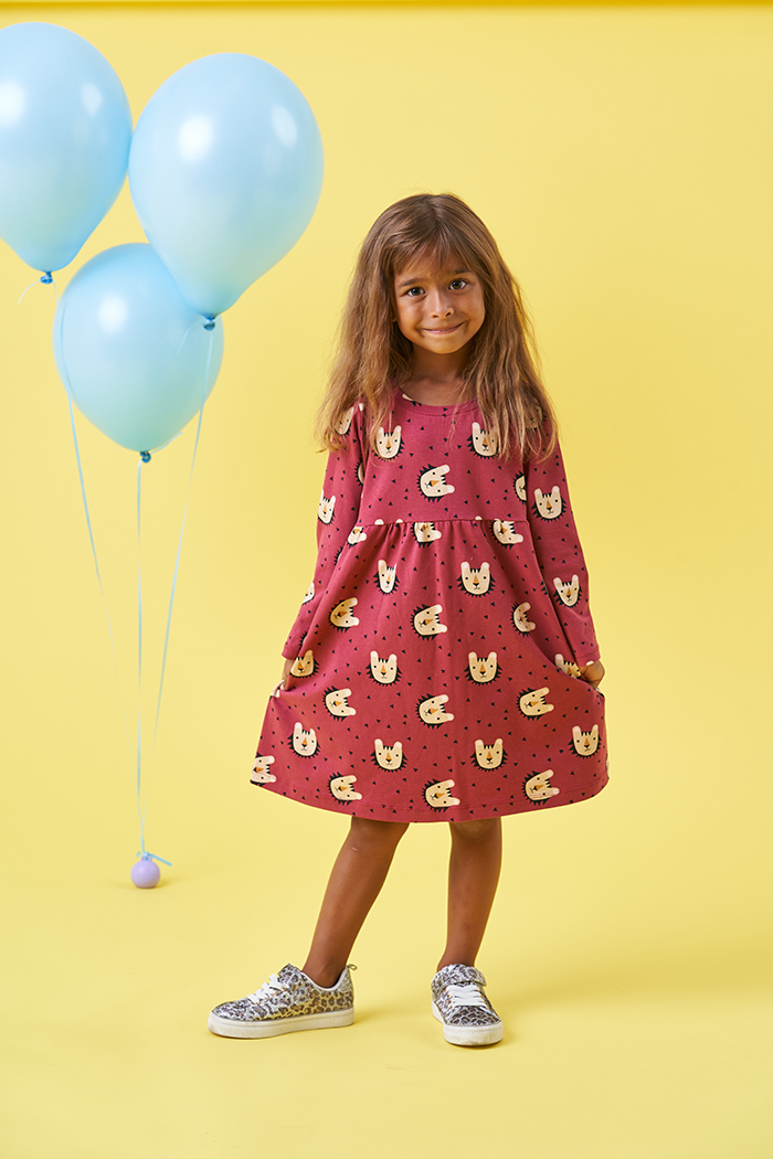 Child wearing the Baby/Child Pansy Dress sewing pattern from Poppy & Jazz on The Fold Line. A dress pattern made in cotton jersey, thin ponte di roma or french terry fabrics, featuring a round neck, full length sleeves and bodice with gathered skirt.