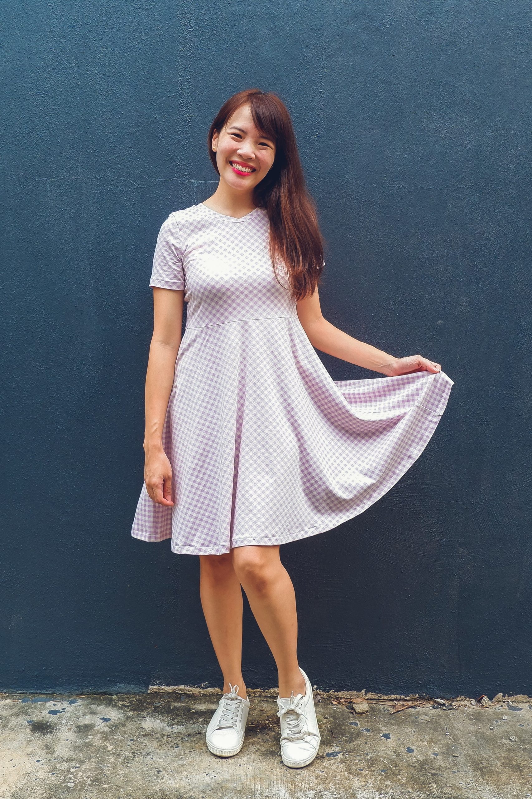 Woman wearing the Stephanotis Dress sewing pattern from Waves & Wild on The Fold Line. A dress pattern made in cotton/lycra jersey fabrics, featuring a circle skirt, short sleeves, side seam pockets, round neck and above knee length.