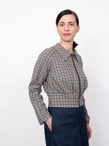 Woman wearing the Cropped Jacket sewing pattern from The Assembly Line on The Fold Line. A jacket pattern made in mid-weight fabrics, featuring a short length, raglan sleeves, wide waistband, front zipper opening, full length sleeves and pointed collar.