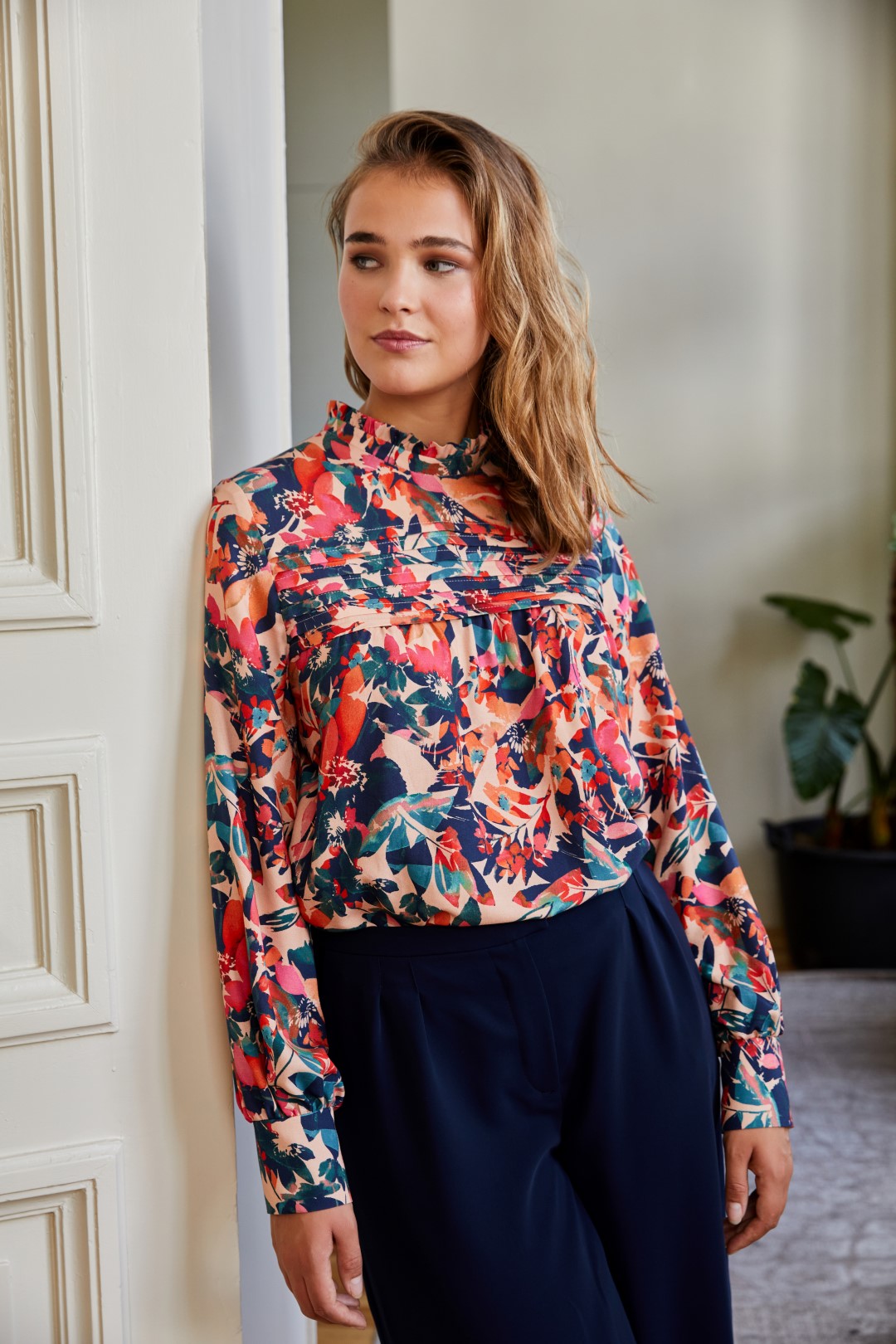 Woman wearing the Emma Blouse sewing pattern from Atelier Jupe on The Fold Line. A blouse pattern made in viscose, tencel or non-static polyester fabrics, featuring a loose fit, V-neck, bust darts, voluminous three-quarter sleeves with gathered cuff,