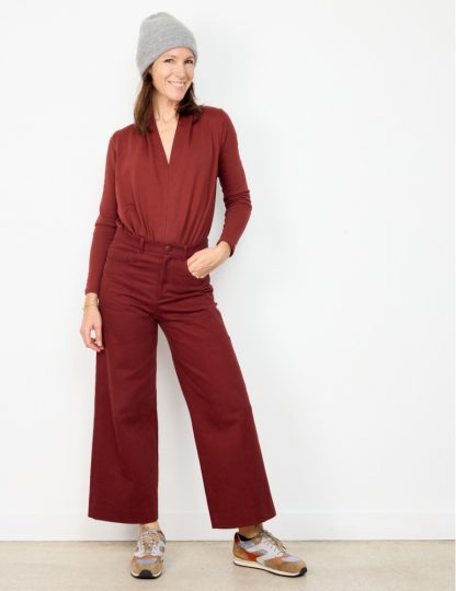 Woman wearing the California Pants sewing pattern from Atelier Scämmit on The Fold Line. A trouser pattern made in serge or denim fabrics, featuring a wide-leg, mid-rise waist, front fob and rounded pockets, topstitched yoke, back patch pockets, fly zip and cropped length.