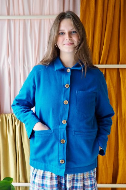 Woman wearing the Lunar Jacket sewing pattern from The New Craft House on The Fold Line. A jacket pattern made in cotton drill, twill, canvas or heavy jacquard fabrics, featuring a double-layered welt pocket, classic collar, hip length, straight fit, full length sleeves and button front closure.
