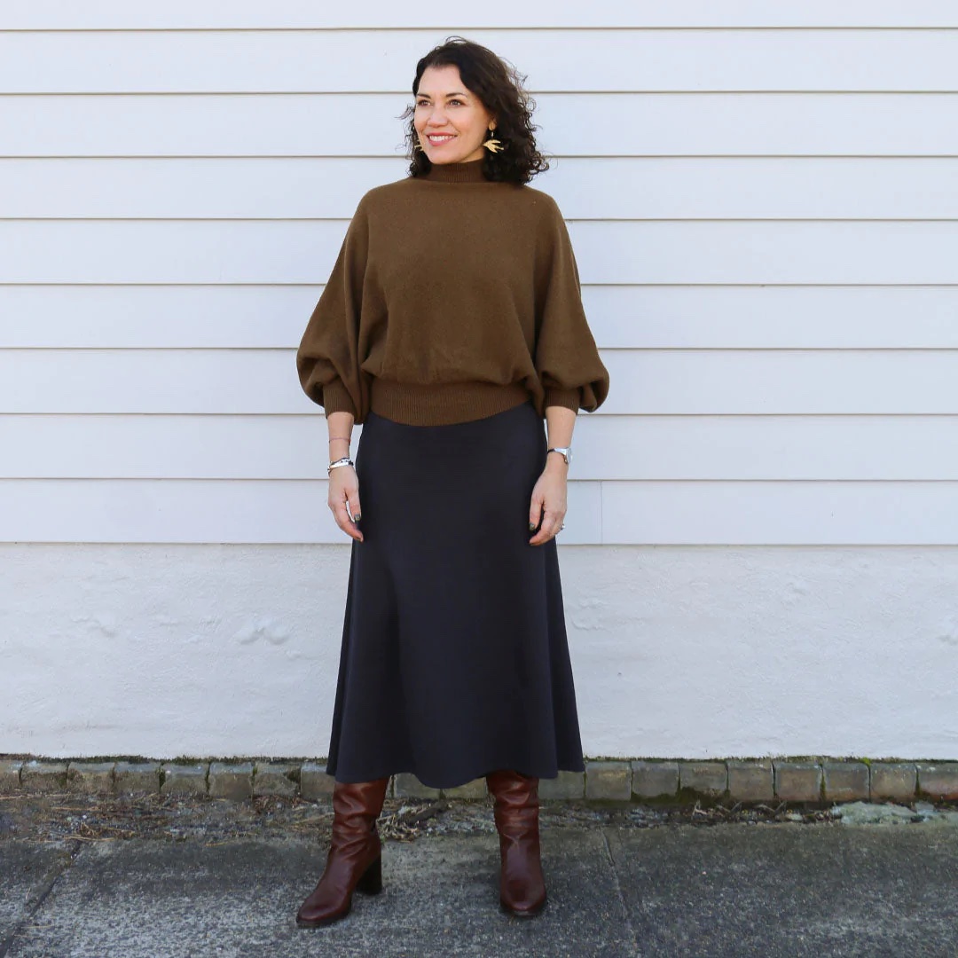 Woman wearing the Mahlia Skirt sewing pattern from Tessuti Fabrics on The Fold Line. A skirt pattern made in ponti knit, stretch velvet jersey or viscose/elastane jersey fabrics, featuring an A-line silhouette, fitted through the waist and hips, subtle curved hi-low mid-calf hem, wide elastic waistband and twin-needle topstitching.