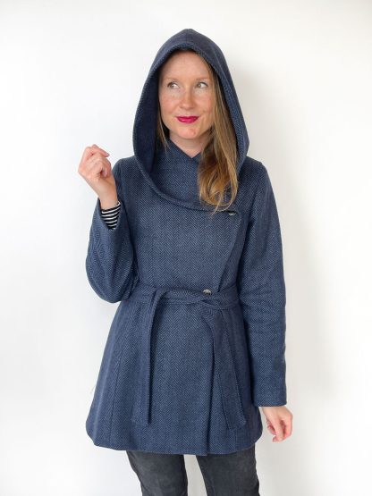 Woman wearing the Willa Wrap Coat with Hood sewing pattern from Jennifer Lauren Handmade on The Fold Line. A hood pattern made in melton, boucle, herringbone, tweed, suitings, corduroy or light quilted fabrics, featuring pattern pieces to make a wide, deep, draped hood with button or snap closure.