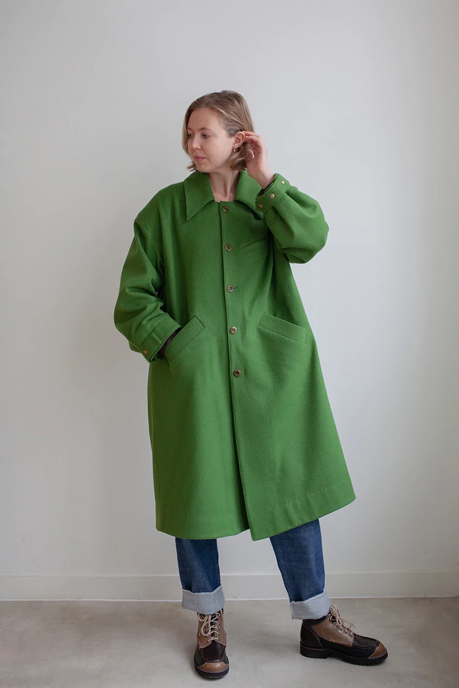 Woman wearing the Darcy Coat sewing pattern from The Modern Sewing Co on The Fold Line. A coat pattern made in wool, waxed cotton, linen/hemp, gabardine, denim fabrics featuring an oversized fit, dropped shoulder, deep armholes, wide sleeves, wide main body, welt pockets, front button closure, collar and cuffs.