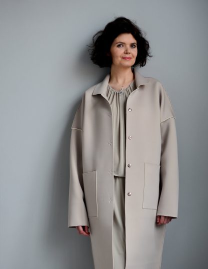 Woman wearing the Unlined Raw-edged Coat sewing pattern from The Maker's Atelier on The Fold Line. A coat pattern made in felted and boiled wools, hi-tech synthetics, neoprene and bonded fabrics, featuring dropped shoulders, patch pockets, over long sleeves, front button closure, oversized silhouette, collar, stand and lapels.