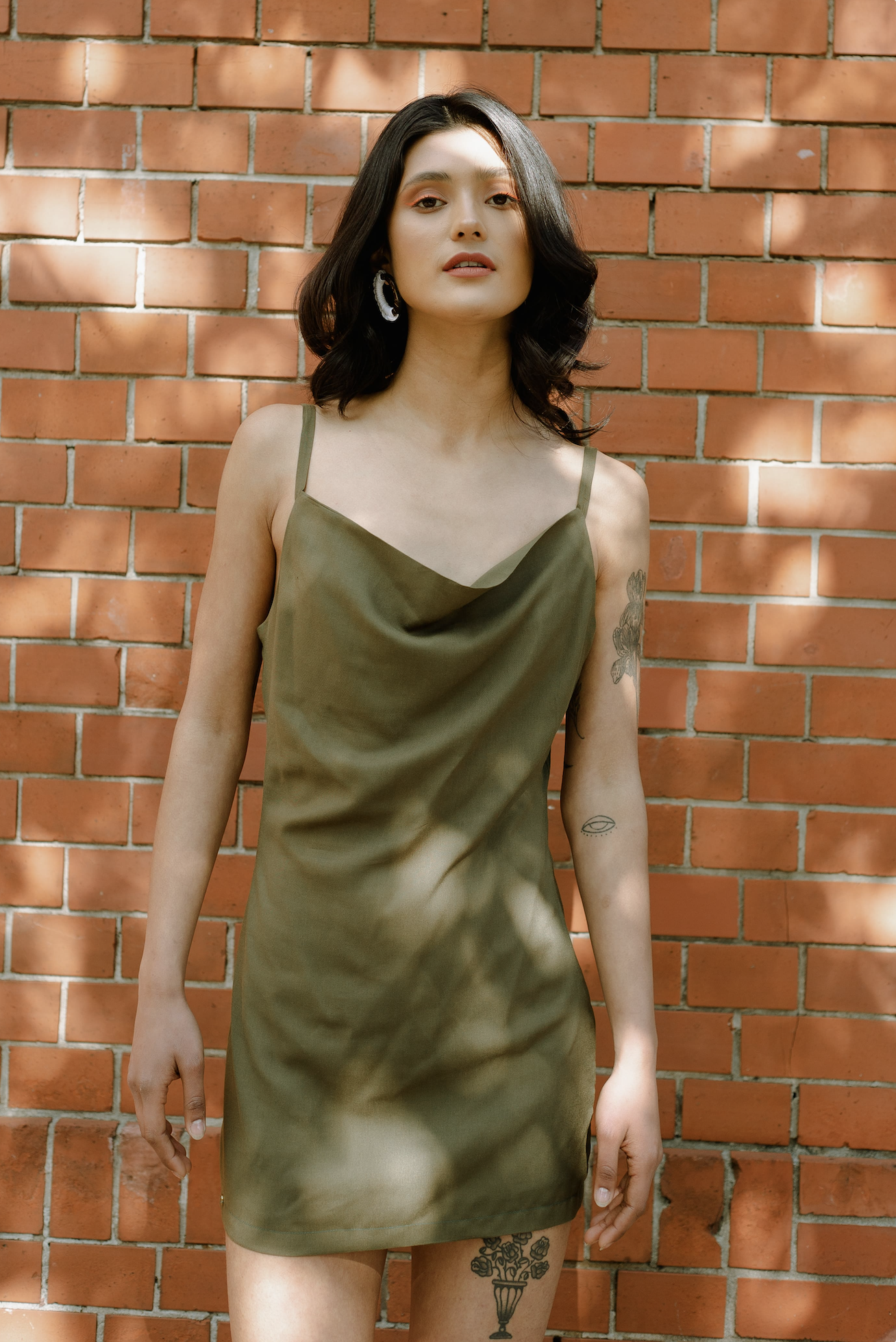 Woman wearing the Delilah Dress sewing pattern from JULIANA MARTEJEVS on The Fold Line. A slip dress pattern made in viscose fabrics, featuring a low waterfall neckline, spaghetti straps and mini length.