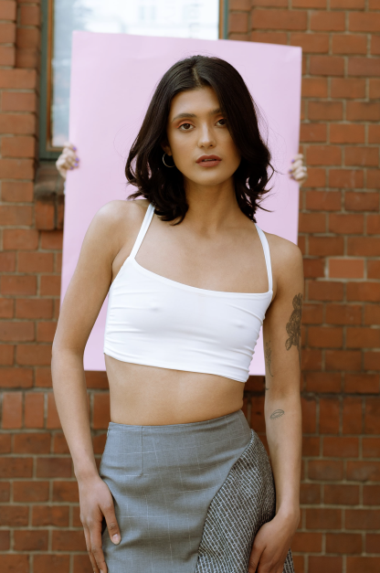 Woman wearing the Vicy Top sewing pattern from JULIANA MARTEJEVS on The Fold Line. A crop top pattern made in cotton jersey fabrics, featuring a cropped length, low square neckline and narrow shoulder straps crossed at the back.