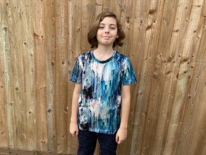 Child wearing the Tween/Teen Boy’s Triple T T-shirt sewing pattern from Waves & Wild on The Fold Line. A T-shirt pattern made in cotton/Lycra jersey, rayon/Lycra jersey, or bamboo/Lycra jersey fabrics, featuring short sleeves, relaxed fit, crew neck and straight hem.