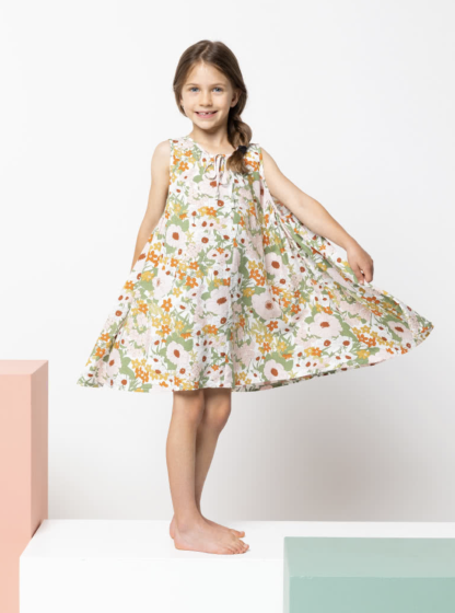 Child wearing the Children’s Heidi Dress sewing pattern from Style Arc on The Fold Line. A Dress pattern made in rayon, silk, or voile fabrics, featuring a loose fit, neckline gathers, front neck ties, deep gathered armholes and high-low hemline.