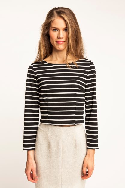 Woman wearing the Kanerva Button-back Tee sewing pattern by Named. A T-shirt pattern made in ponte, French terry or light sweatshirting fabrics, featuring long sleeves, cropped hem, back button closure, bust and waist darts, and boat neckline.