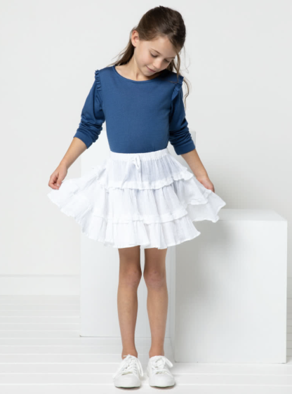 Child wearing the Children’s Melody Skirt sewing pattern from Style Arc on The Fold Line. A Skirt pattern made in rayon, or cotton fabrics, featuring three-tiers, gathered skirt with drawstring, elasticated waist, narrow frills and above knee length.