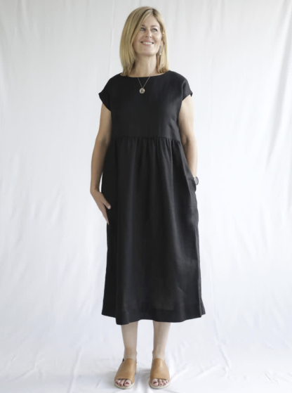 Woman wearing the Montana Midi Dress sewing pattern from Style Arc on The Fold Line. A dress pattern made in washed linen, rayon, crepe or knit fabrics, featuring a pull-on style, extended shoulder line, loose silhouette, high waist with slight gathers, in-seam pockets and midi length.